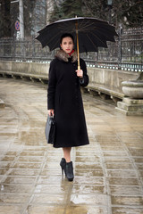 Confident business woman with umbrella