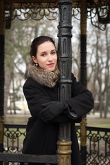 Attractive young Woman posing by a pole