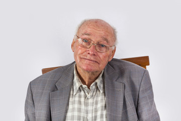portrait of elderly smart confident man sitting in his armchair