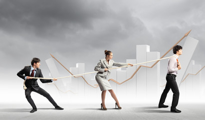 Three business people pulling rope
