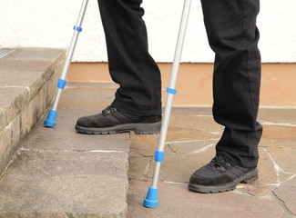 Person mit Kruecken beim Treppensteigen