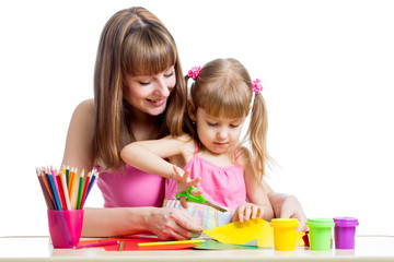 Mother teaches preschooler kid to do craft items. DIY concept.