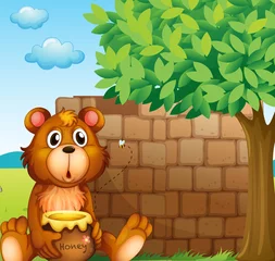  Een beer met honing bij een stapel stenen © GraphicsRF