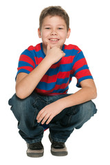 Handsome smiling boy sits on the floor