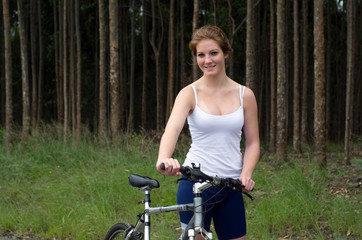 Fototapeta na wymiar Active girl woman in forest with mountain bike