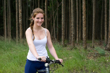 Fototapeta na wymiar Active girl woman in forest with mountain bike