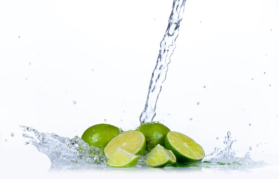 Fresh limes with water splash, isolated on white background