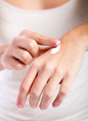 Body care. Woman applying cream on hands