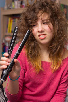 Teenage Girl With Messy Hair And Flatiron Straightener