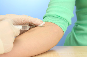 Doctor holding syringe with a vaccine in the patient hand,