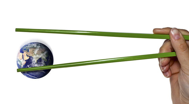 Lost or caught blue planet earth between green chopsticks
