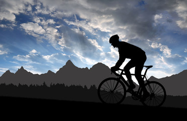 silhouette of the cyclist riding a road bike at sunset