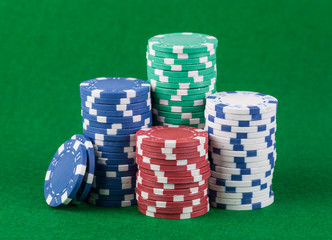 Poker chips on green playing table background