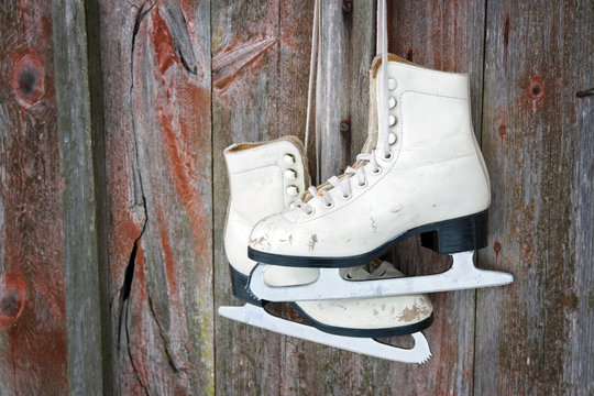 Old skates hanging on a wooden wall