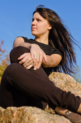 Attractive woman sitting on a rock