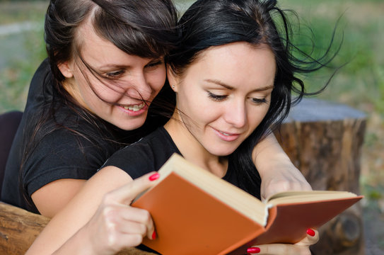 Two Close Woman Friends Enjoying A Book