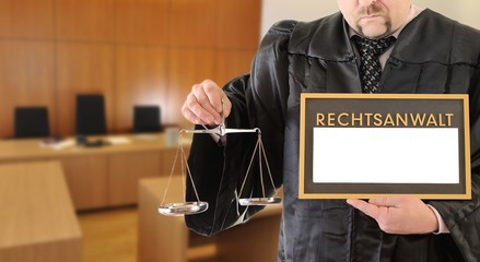 Rechtsanwalt mit Waage und Schild im Gerichtssaal