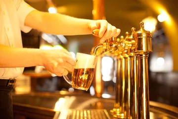 Türaufkleber Kellner zapft ein Bier aus einem goldenen Zapfen © habrda