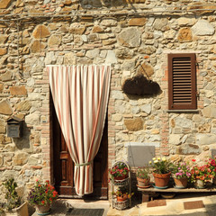 doorway to the tuscan house with striped outdoor curtain
