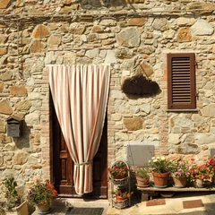 Fotobehang deuropening naar het Toscaanse huis met gestreept buitengordijn © Malgorzata Kistryn