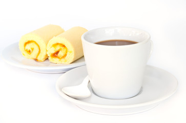 Coffee cup with orange cake roll.
