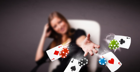 Young woman playing with poker cards and chips