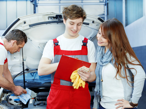 Customer and mechanic in a garage looking at a quotation
