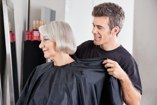 Hairdresser Removing Client's Apron After Haircut