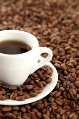 Cup of coffee on coffee beans background