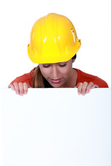 Female manual worker staring at blank poster