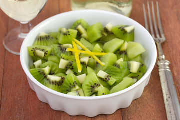 kiwi in the white bowl with glass of wine