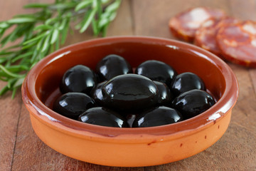 black olives in dish with sausages
