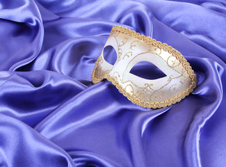 gold carnival mask on blue silk fabric