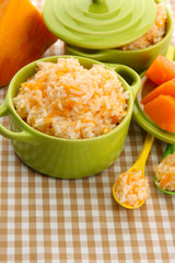 Taste rice porridge with pumpkin in saucepans
