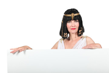 Woman in Cleopatra costume with blank board ready for text