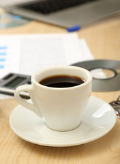 Cup of coffee on office desktop close-up