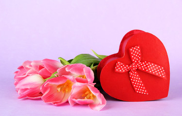 Pink tulips and gift box, on color background