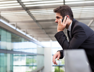 Young business man talking on cell phone at modern office