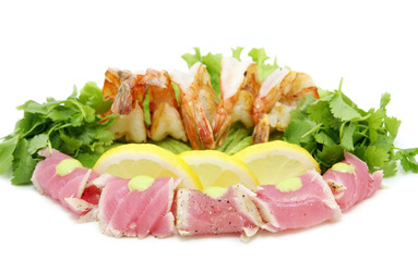 shrimp and tuna with greens and sauce on a white background