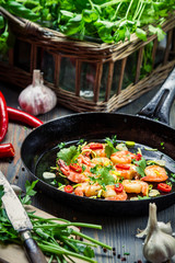 Closeup of shrimps served on a pan with herbs