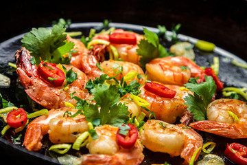 Closeup of shrimps on pan with herbs