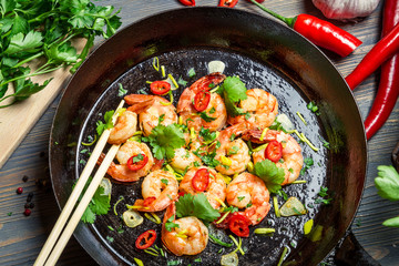 Closeup of shrimps on pan with fresh herbs