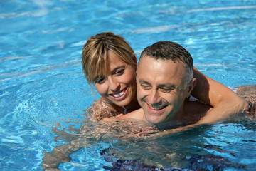 Couple swimming in hotel pool