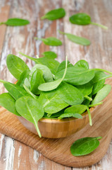 Fresh spinach in a wooden bowl, vertical