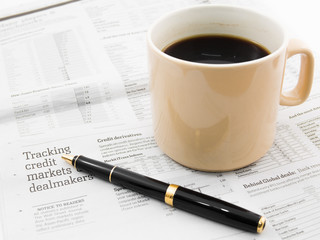 Morning coffee and pen on a morning paper business news