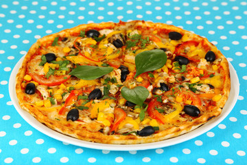 Tasty pizza on blue tablecloth close-up