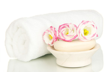 Fototapeta na wymiar Rolled biały ręcznik, mydła i piękny kwiat wyizolowanych
