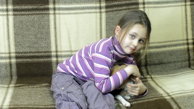 A girl plays with a puppy