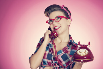 Happy pin up girl talking on retro telephone