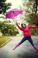 Cheerful woman jumping with umbrella.